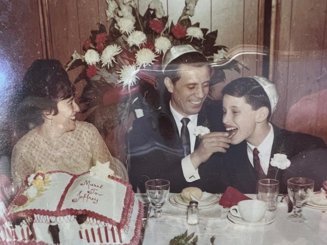 Yisroel Meir (Jeffrey) at his bar mitzvah with YoungPa and YoungMa, beside a cake that reads Mazel Tov Jeffrey.