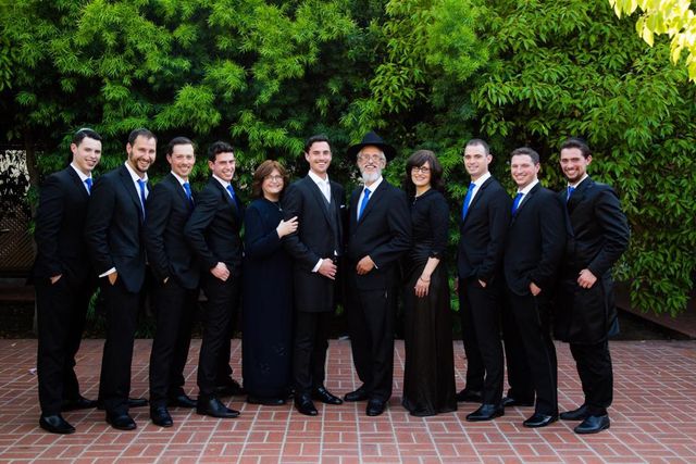 Rabbi Yisroel Meir Vogel and Victoria outdoors with their nine children.